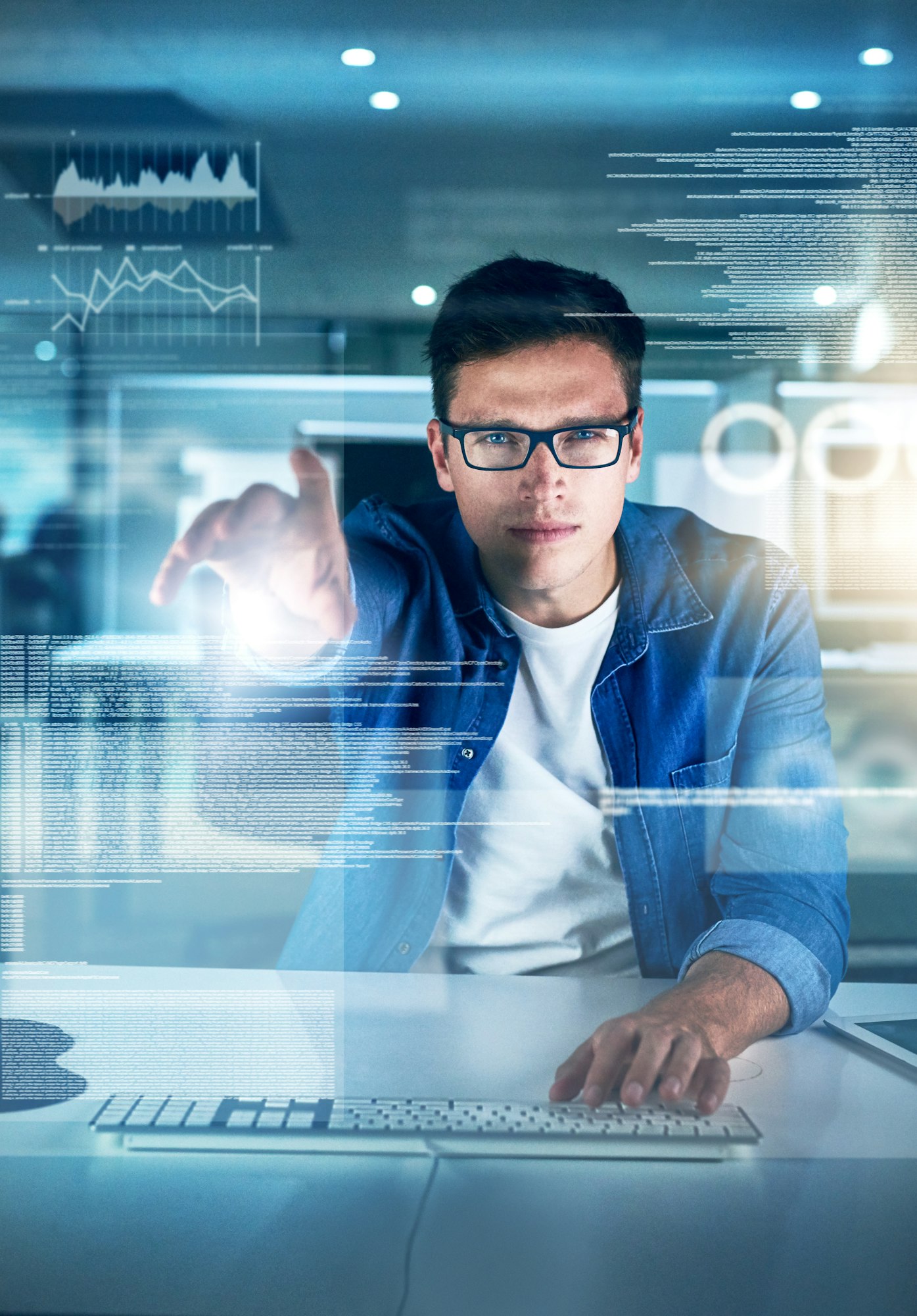 Portrait of a focused young programmer working on his computer in the office during the night